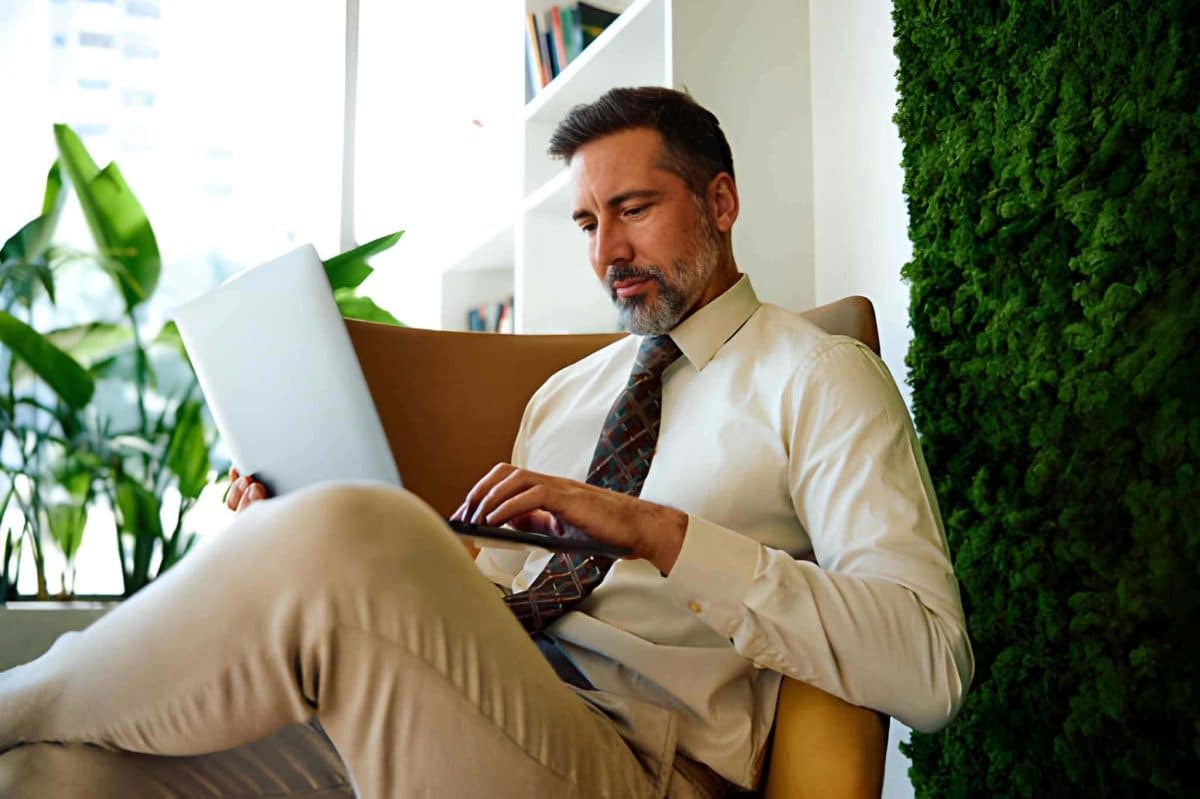 Homme travaillant sur un ordinateur portable à l’intérieur