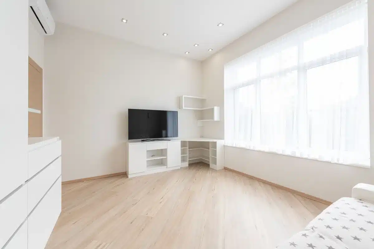 Meuble TV d'angle moderne intégré dans un coin de salon avec rangements