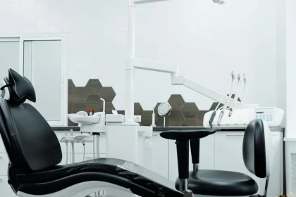 Salle d'attente de cabinet dentaire avec murs vert sauge, mobilier accueillant et éclairage chaleureux