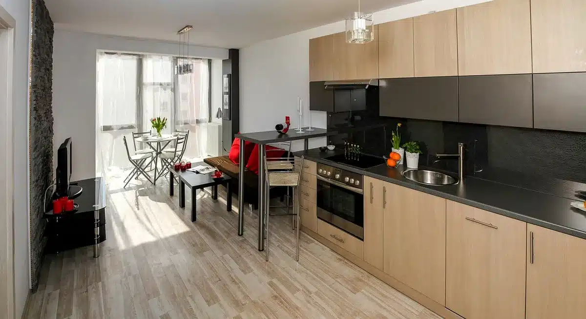 Îlot central dans une cuisine ouverte baignée de lumière, séparant cuisine et salon