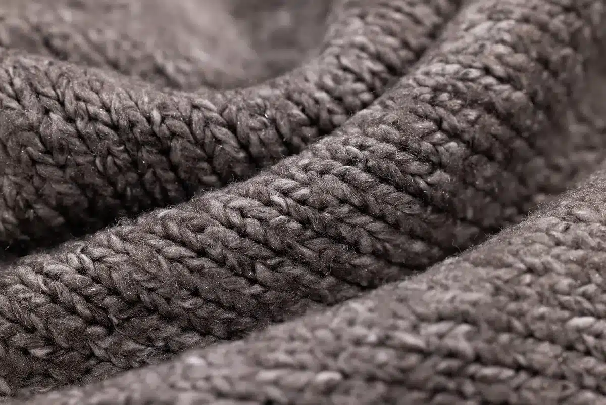 Détail d'un meuble en bois clair et textiles doux